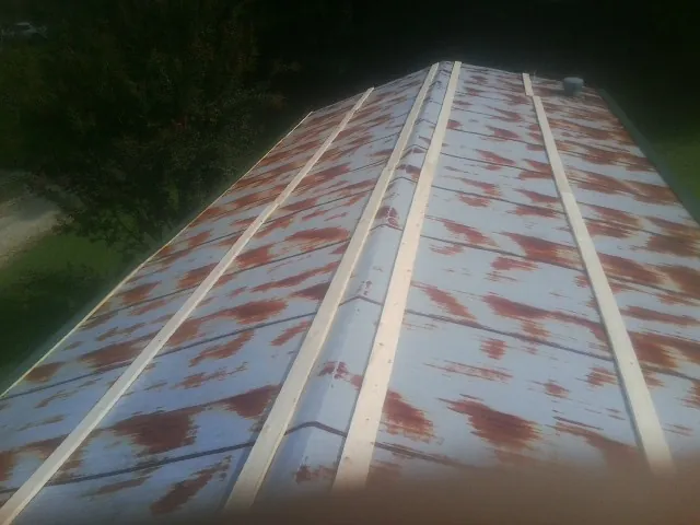 Rusted metal roof panels with new wood purlins before replacement — Storm Damage Roof Repair in Singers Glen by Roofing Brothers