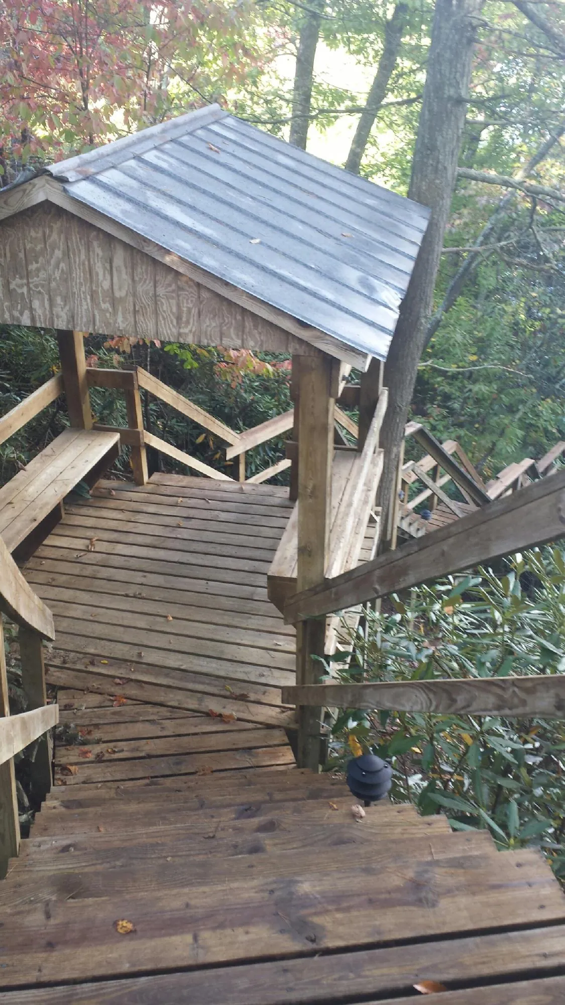 Metal roofed shelter over wooden steps on a wooded walkway — Skylight Repair & Installation work by our crew in Singers Glen
